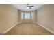 The living room has tan carpet, a ceiling fan, and windows giving lots of natural light at 1041 Flat Rock Rd, Covington, GA 30014