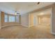 This living room has a window, a ceiling fan, tan carpet, and a view into another room at 1041 Flat Rock Rd, Covington, GA 30014