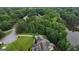 Scenic aerial view of a home featuring lush green lawns and a long driveway, set against a backdrop of dense, mature trees at 81 Smokerise Pt, Peachtree City, GA 30269
