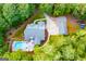 Aerial view of a home with a spacious backyard, swimming pool, detached garage, and lush greenery at 7003 Tara Dr, Villa Rica, GA 30180