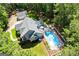 This aerial view captures the home's yard and pool with mature tree coverage and detached garage at 7003 Tara Dr, Villa Rica, GA 30180