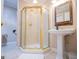 Bathroom features a pedestal sink, gold-trimmed mirror, and a glass-enclosed shower at 7003 Tara Dr, Villa Rica, GA 30180