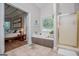 Bathroom showcases a beautiful bathtub with natural light and a glass door shower at 7003 Tara Dr, Villa Rica, GA 30180
