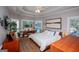 Bright bedroom with tray ceilings, hardwood floors, and a view of the backyard and pool at 7003 Tara Dr, Villa Rica, GA 30180