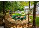Relax in this backyard oasis, featuring a firepit with Adirondack chairs and mature trees at 7003 Tara Dr, Villa Rica, GA 30180