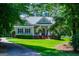 Charming single-story home with manicured lawn, mature trees, and a welcoming front porch at 7003 Tara Dr, Villa Rica, GA 30180