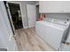 Well-lit laundry room with modern washer and dryer units and neutral vinyl floors at 7003 Tara Dr, Villa Rica, GA 30180