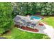 Aerial view of a cozy home with a pool and well-maintained grounds, surrounded by lush greenery and mature trees at 185 Downybrook Ln, Fayetteville, GA 30215