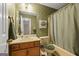 Bathroom with a floral wallpaper, vanity with framed mirror, and a bathtub with shower showcasing a serene design at 185 Downybrook Ln, Fayetteville, GA 30215