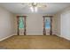 Spacious bedroom features carpeted floors, ceiling fan, and bright windows, offering comfort and style at 185 Downybrook Ln, Fayetteville, GA 30215