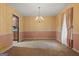 A spacious dining room with traditional wallpaper and trim, leading into the kitchen at 185 Downybrook Ln, Fayetteville, GA 30215