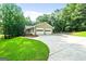 Charming home with a two-car garage, beautiful landscaping, and a circular driveway leading to a well-maintained property at 185 Downybrook Ln, Fayetteville, GA 30215