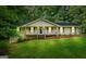 Charming single-Gathering home featuring a covered front porch and a well-maintained lawn with mature trees at 185 Downybrook Ln, Fayetteville, GA 30215