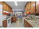 Open kitchen with wood cabinetry, granite counters, mosaic backsplash, and breakfast nook by bay window at 185 Downybrook Ln, Fayetteville, GA 30215