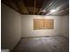 Unfinished basement space ready for renovation with visible ceiling and plywood covered window at 101 Pinetree Trl, Atlanta, GA 30349