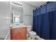 A bathroom vanity sink is showcased with a toilet and shower with a blue shower curtain at 1209 Polk Xing, Mcdonough, GA 30252