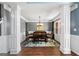 Dining room with hardwood floors, gray walls, a stylish light fixture, and wainscoting at 1209 Polk Xing, Mcdonough, GA 30252