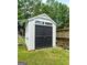 A spacious shed features a dark door and windows with a lush lawn and wood fence at 1209 Polk Xing, Mcdonough, GA 30252