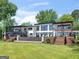 Expansive backyard of a modern two-story home with a waterfall feature, manicured lawn, and access to upper-level balconies at 2775 Club Valley Ct, Jonesboro, GA 30236