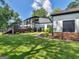 Spacious backyard featuring a manicured lawn, access to upper-level balconies, and a view of the home's modern design at 2775 Club Valley Ct, Jonesboro, GA 30236