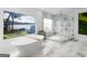 Luxury bathroom featuring a soaking tub, marble floors, and a glass-enclosed shower with lake view at 2775 Club Valley Ct, Jonesboro, GA 30236