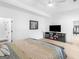 Bright bedroom featuring a sleek entertainment center, ceiling fan, and an ensuite bathroom for a modern feel at 2775 Club Valley Ct, Jonesboro, GA 30236