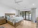 This well-lit primary bedroom boasts hardwood floors, a comfortable bed, and sliding glass doors with stunning lake views at 2775 Club Valley Ct, Jonesboro, GA 30236