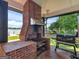 Covered outdoor kitchen area featuring a brick grill, bar area, and views of the lake at 2775 Club Valley Ct, Jonesboro, GA 30236
