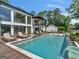 Stunning backyard pool area with a waterfall feature, multiple lounge areas and a modern home exterior at 2775 Club Valley Ct, Jonesboro, GA 30236
