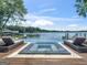 Relaxing pool and jacuzzi with lake views, complemented by stylish lounge chairs on a wooden deck at 2775 Club Valley Ct, Jonesboro, GA 30236