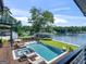 Elevated aerial view of the pool, patio furniture, manicured yard, and lake at 2775 Club Valley Ct, Jonesboro, GA 30236