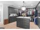 Spacious walk-in closet with gray cabinetry, marble island, and a sparkling chandelier at 2775 Club Valley Ct, Jonesboro, GA 30236