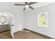 A bright bedroom with wood-look floors, a ceiling fan, and an open door to the bathroom at 437 Collier Ridge Nw Dr, Atlanta, GA 30318