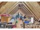 Unfinished attic space with exposed beams, plywood floor, and visible storage items at 3511 Cherry Blossom Ct, Loganville, GA 30052