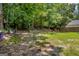 Expansive backyard with lush greenery, mature trees, and a charming picnic area for outdoor enjoyment at 3511 Cherry Blossom Ct, Loganville, GA 30052