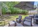 Relaxing outdoor patio featuring comfortable seating shaded by large umbrellas, ideal for enjoying the backyard at 3511 Cherry Blossom Ct, Loganville, GA 30052