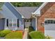 Inviting front entrance with a white door, surrounded by lush greenery and tasteful landscaping at 3511 Cherry Blossom Ct, Loganville, GA 30052