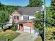 Aerial view of a two story house with a driveway and a two car garage at 1399 Cutters Mill Dr, Lithonia, GA 30058