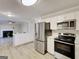 Modern kitchen with stainless steel appliances and a breakfast bar open to the living area at 1399 Cutters Mill Dr, Lithonia, GA 30058