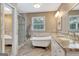 Bright bathroom featuring herringbone floors, standalone tub, and a glass shower at 522 Golfview, Peachtree City, GA 30269