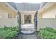 Charming courtyard entrance featuring brick walls, a decorative metal gate, and landscaped greenery at 522 Golfview, Peachtree City, GA 30269