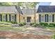 Elegant home entrance with black double doors, complemented by stylish landscaping, exudes sophistication at 522 Golfview, Peachtree City, GA 30269
