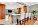 Open kitchen with stainless steel appliances, wood cabinets, an island with seating, and gleaming hardwood floors at 522 Golfview, Peachtree City, GA 30269