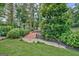 Lush backyard landscaping with a wooden bridge, manicured mulch beds, and a white picket fence at 522 Golfview, Peachtree City, GA 30269
