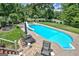 Relaxing outdoor space with a swimming pool, slide, patio seating, and well-manicured landscaping creates a private oasis at 522 Golfview, Peachtree City, GA 30269
