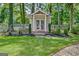 Backyard storage shed featuring double doors, surrounded by manicured landscaping and a picket fence at 522 Golfview, Peachtree City, GA 30269