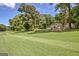 Manicured lawn with mature trees and a view of the house and white picket fence in the background at 522 Golfview, Peachtree City, GA 30269