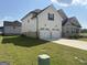 Side view of a two-story home with a two-car garage, showcasing the well-manicured lawn and modern design at 13709 Whitman Ln, Covington, GA 30014