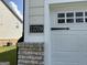 Close-up of the house number '13709' next to a white garage door with decorative windows at 13709 Whitman Ln, Covington, GA 30014