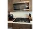 Modern kitchen with stainless steel microwave, gas range, and knife block on countertop at 13709 Whitman Ln, Covington, GA 30014